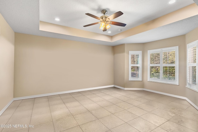unfurnished room with ceiling fan, light tile patterned floors, baseboards, a tray ceiling, and recessed lighting