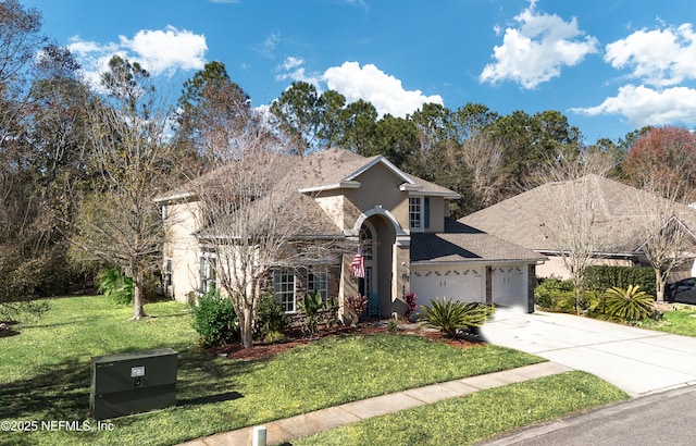 traditional home with a garage, stone siding, a front yard, stucco siding, and driveway