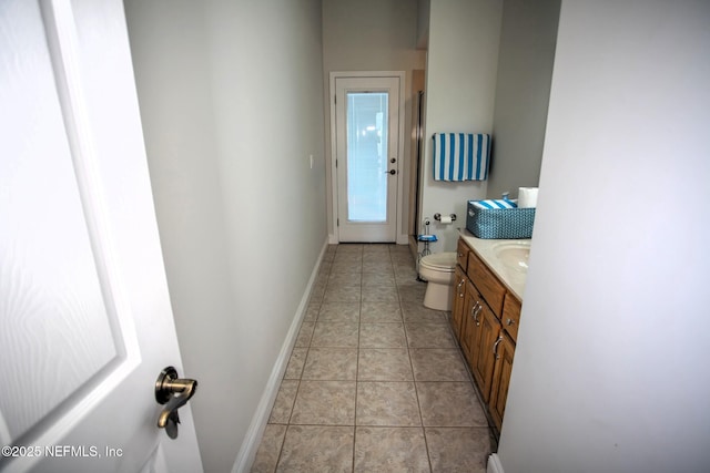 bathroom with tile patterned floors, vanity, toilet, and baseboards
