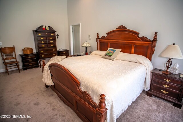 bedroom featuring baseboards and light carpet