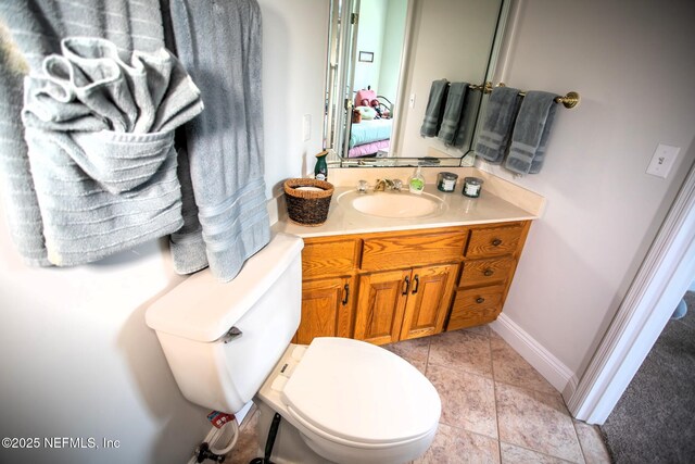 half bathroom featuring baseboards, toilet, and vanity