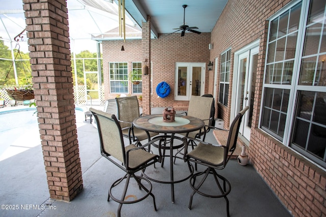 view of patio with a lanai, a ceiling fan, and french doors