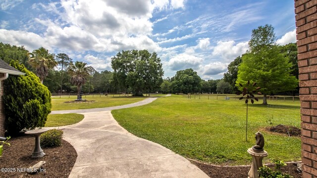 view of community featuring a lawn and fence