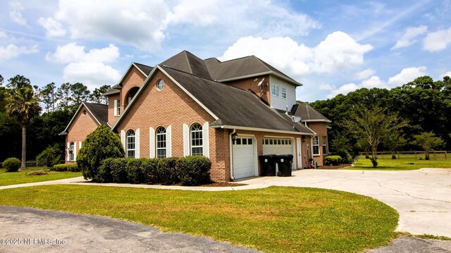 view of property exterior with a yard, brick siding, a shingled roof, driveway, and an attached garage