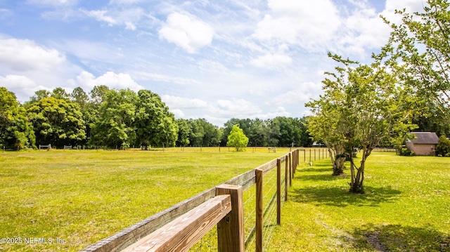 view of yard featuring fence and a rural view