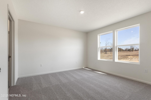 unfurnished bedroom with a textured ceiling, carpet flooring, and baseboards