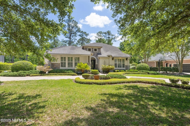 view of front of home featuring a front lawn, stucco siding, and stone siding