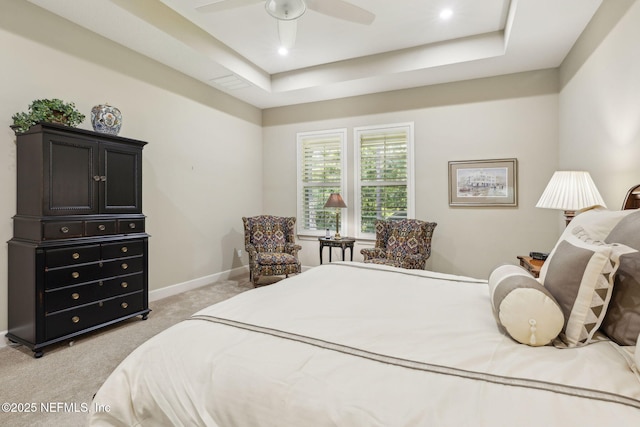bedroom featuring light colored carpet, a ceiling fan, a raised ceiling, and baseboards