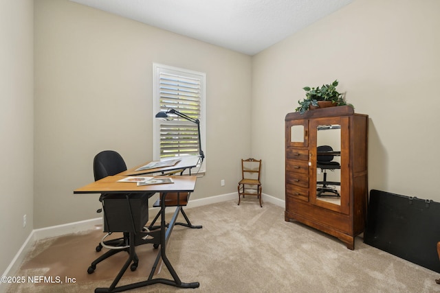 home office with baseboards and light colored carpet