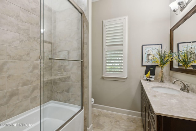 bathroom with vanity, toilet, baseboards, tile patterned floors, and combined bath / shower with glass door