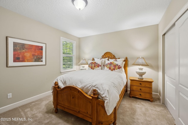 carpeted bedroom with a closet, a textured ceiling, and baseboards