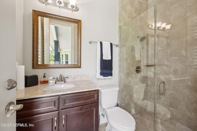 full bath featuring vanity, a stall shower, and toilet