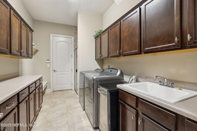 laundry area with cabinet space, separate washer and dryer, light tile patterned flooring, and a sink