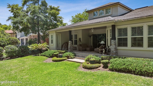 back of house with a ceiling fan, a lawn, a patio area, an outdoor hangout area, and stucco siding