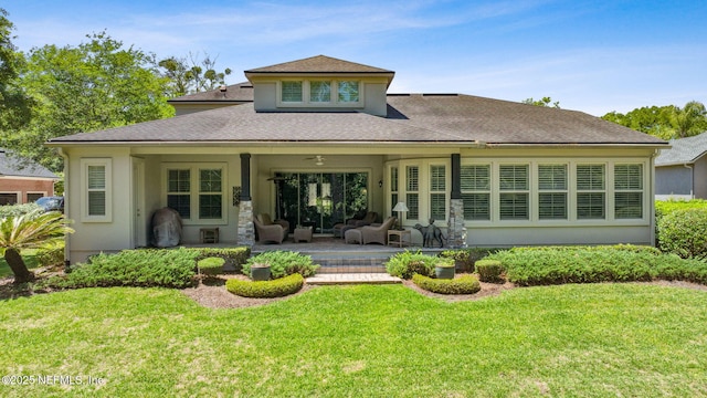 rear view of house with a patio, roof with shingles, stucco siding, and a yard