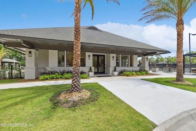 4583 Swilcan Bridge Ln N, Jacksonville, FL 32224 - view of front facade featuring a front lawn, fence, french doors, brick siding, and a shingled roof