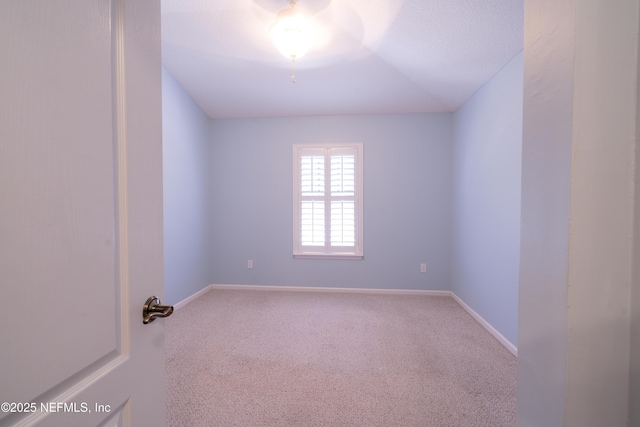 empty room featuring baseboards and carpet