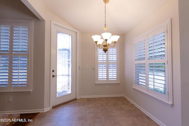 unfurnished dining area featuring baseboards, tile patterned floors, a chandelier, and vaulted ceiling