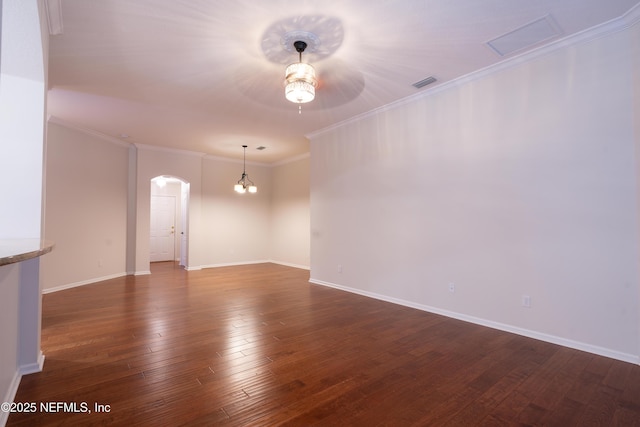 empty room with ceiling fan, arched walkways, baseboards, dark wood-type flooring, and visible vents