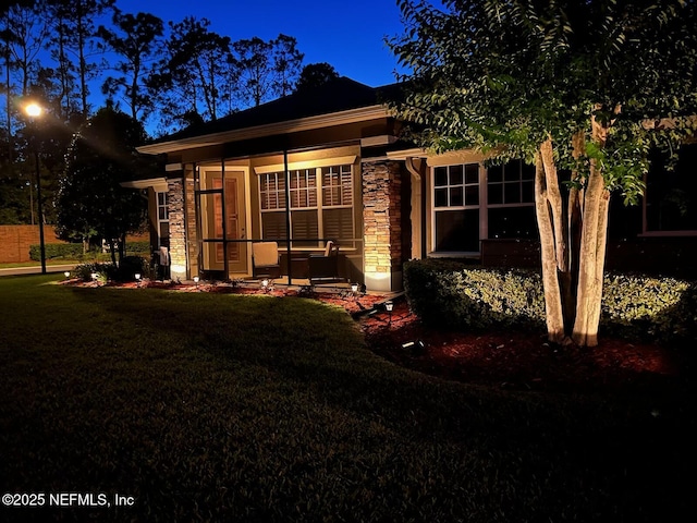 exterior space with a lawn and stone siding