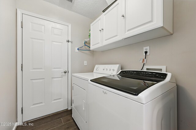 245 Village Green Ave, Fruit Cove, FL 32259 - clothes washing area featuring dark wood-style flooring, washer and dryer, a textured ceiling, and cabinet space