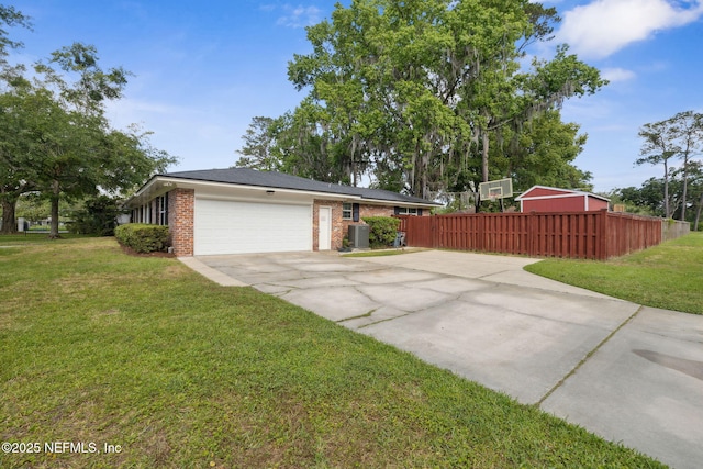 view of home's exterior featuring fence, brick siding, concrete driveway, an attached garage, and a yard