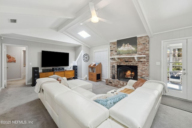 living room with carpet flooring, lofted ceiling with beams, a fireplace, a ceiling fan, and visible vents