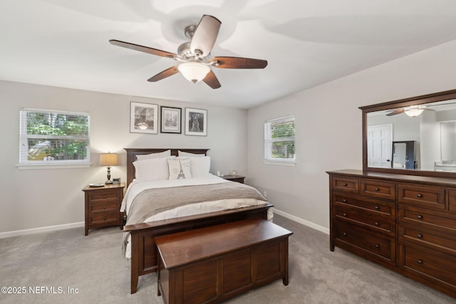 bedroom featuring baseboards, multiple windows, and light carpet