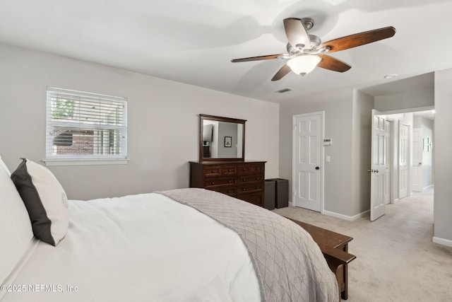bedroom with baseboards, light carpet, a ceiling fan, and visible vents