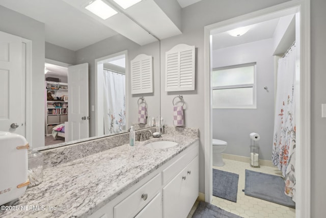 bathroom featuring vanity, baseboards, toilet, and curtained shower