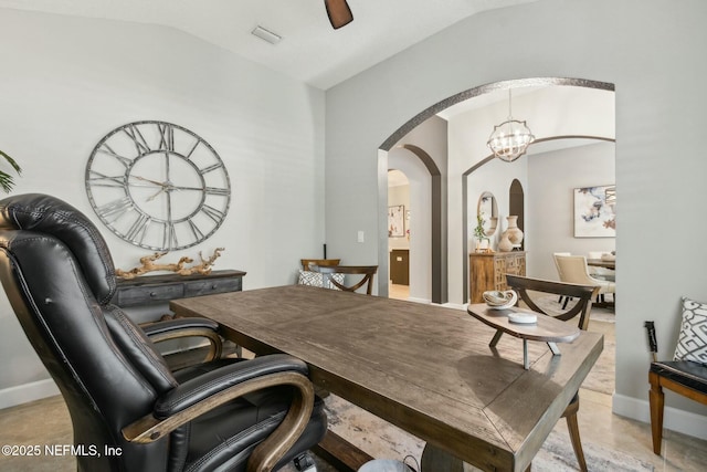 office featuring lofted ceiling, visible vents, baseboards, and arched walkways