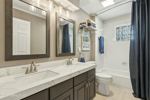 full bathroom featuring toilet, tile patterned flooring, double vanity, and a sink