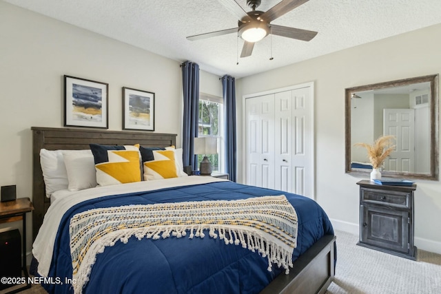 carpeted bedroom featuring a textured ceiling, visible vents, baseboards, a closet, and a ceiling fan