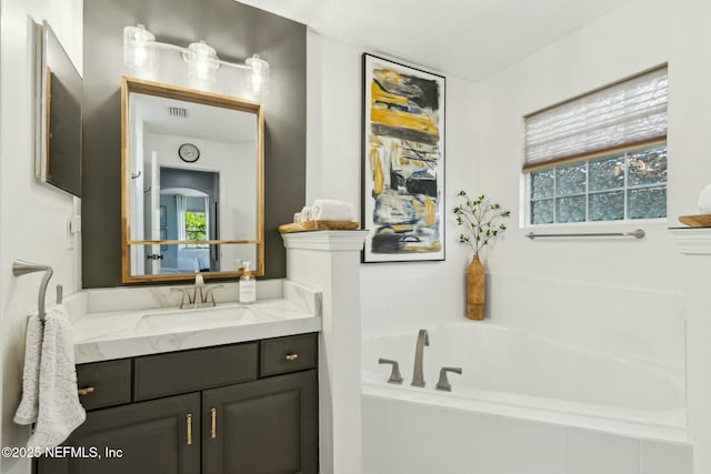 full bath with visible vents, a bath, and vanity