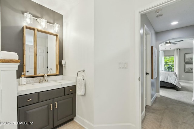 bathroom with connected bathroom, vanity, and baseboards