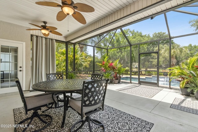 sunroom featuring outdoor dining space, a ceiling fan, and plenty of natural light