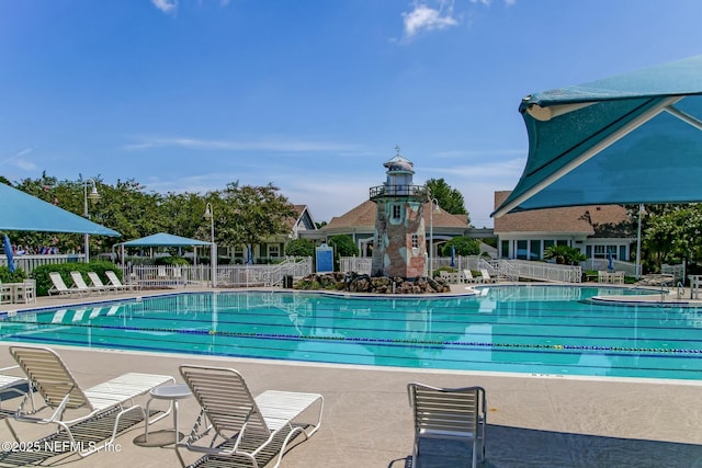 community pool featuring fence and a patio