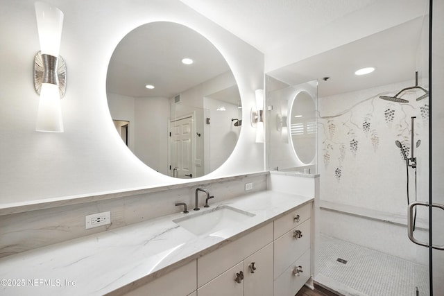 full bathroom with a stall shower, vanity, and recessed lighting