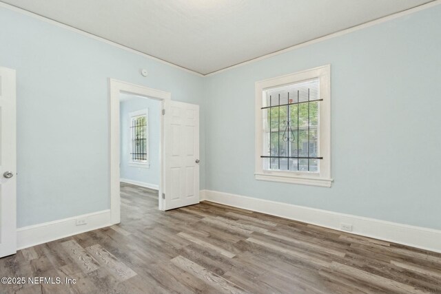 unfurnished room with ornamental molding, wood finished floors, and plenty of natural light