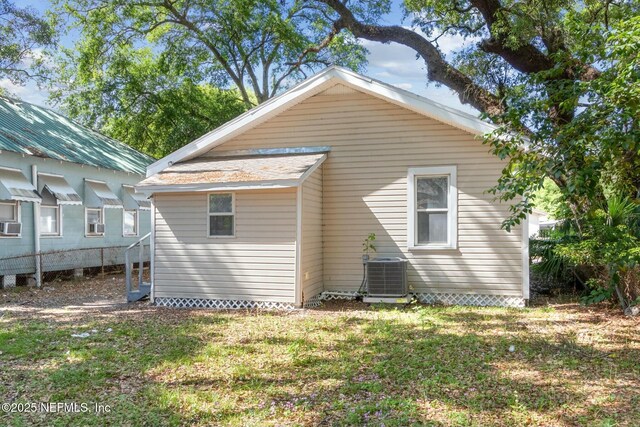 rear view of house with a lawn and central AC