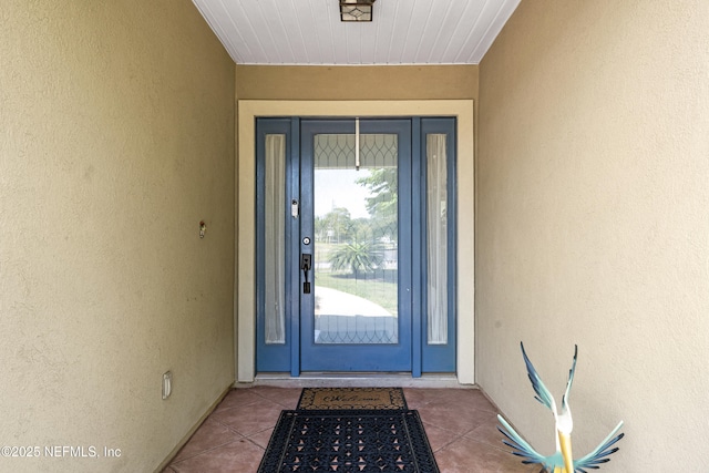 entrance to property featuring stucco siding
