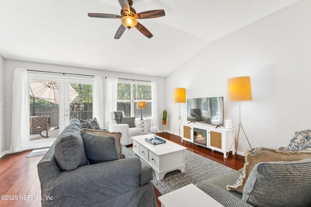 living area with baseboards, vaulted ceiling, ceiling fan, and dark wood-type flooring