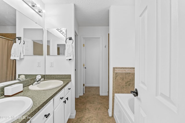 full bath with double vanity, a washtub, a textured ceiling, and a sink