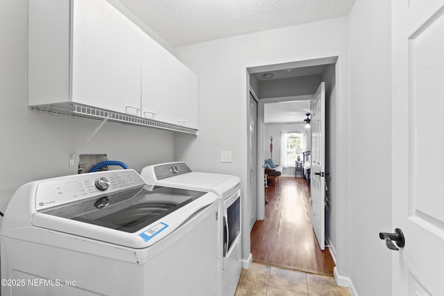washroom featuring washing machine and dryer, ceiling fan, a textured ceiling, cabinet space, and light tile patterned floors