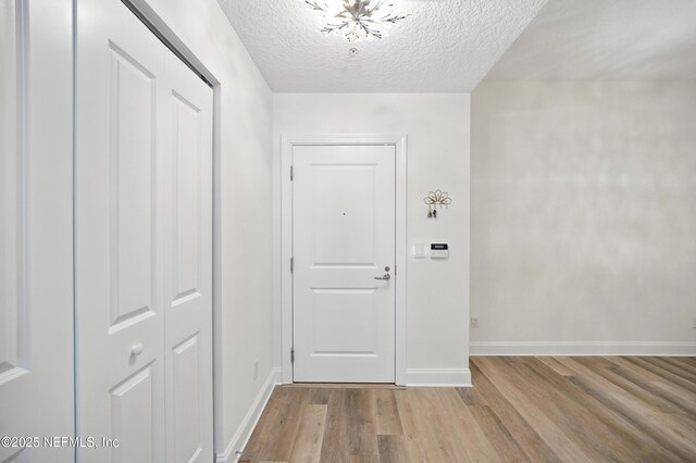 1431 Riverplace Blvd Unit 2003, Jacksonville, FL 32207 - interior space featuring baseboards, a chandelier, a textured ceiling, and light wood-style flooring