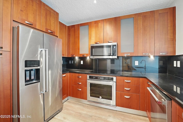 1431 Riverplace Blvd Unit 2003, Jacksonville, FL 32207 - kitchen with stainless steel appliances, light wood finished floors, and brown cabinetry