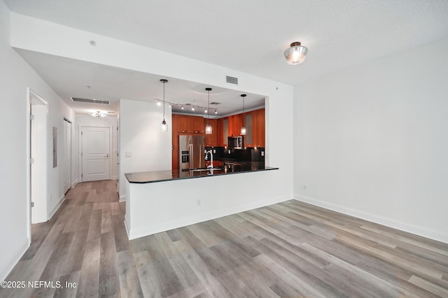 1431 Riverplace Blvd Unit 2003, Jacksonville, FL 32207 - kitchen with light wood-style flooring, appliances with stainless steel finishes, dark countertops, visible vents, and a peninsula