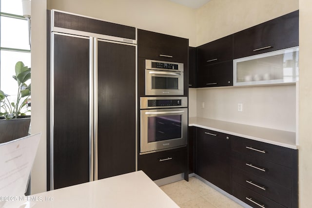 1431 Riverplace Blvd Unit 2003, Jacksonville, FL 32207 - kitchen with stainless steel double oven, light countertops, dark cabinets, and paneled fridge