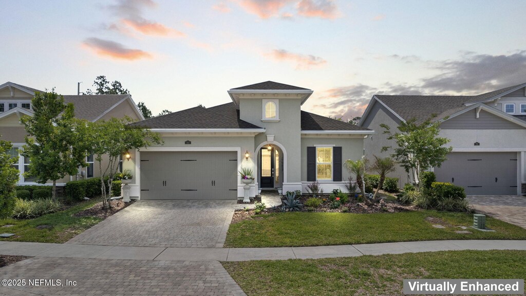 80 Armorer Ct, Jacksonville, FL 32081 - view of front of house featuring a garage, a shingled roof, a yard, decorative driveway, and stucco siding