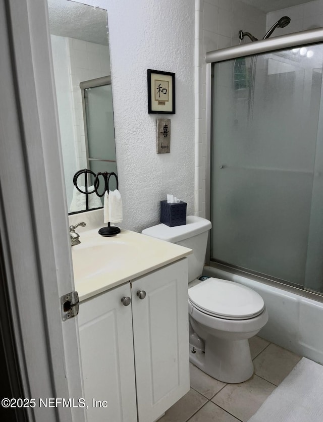 6655 Bell Tower Ct Unit 1, Jacksonville, FL 32217 - bathroom with a textured wall, vanity, toilet, tile patterned floors, and enclosed tub / shower combo